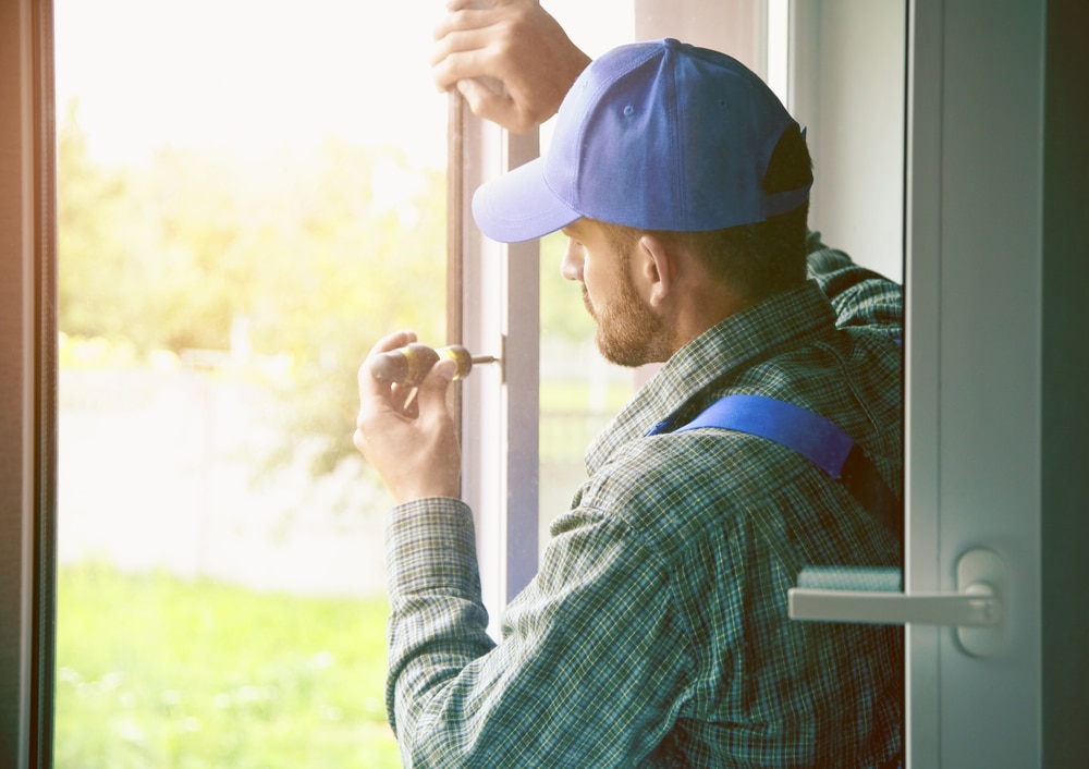 Man installing window using screwdriver