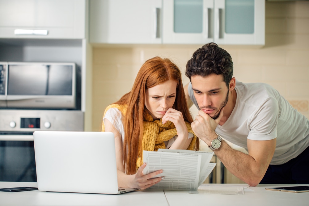 Young couple looking thoughtfully at paperwork