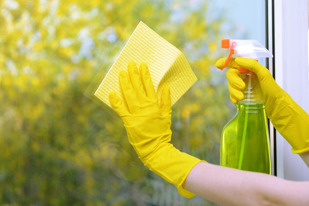 Hand cleaning window with microfiber cloth and cleaning solution