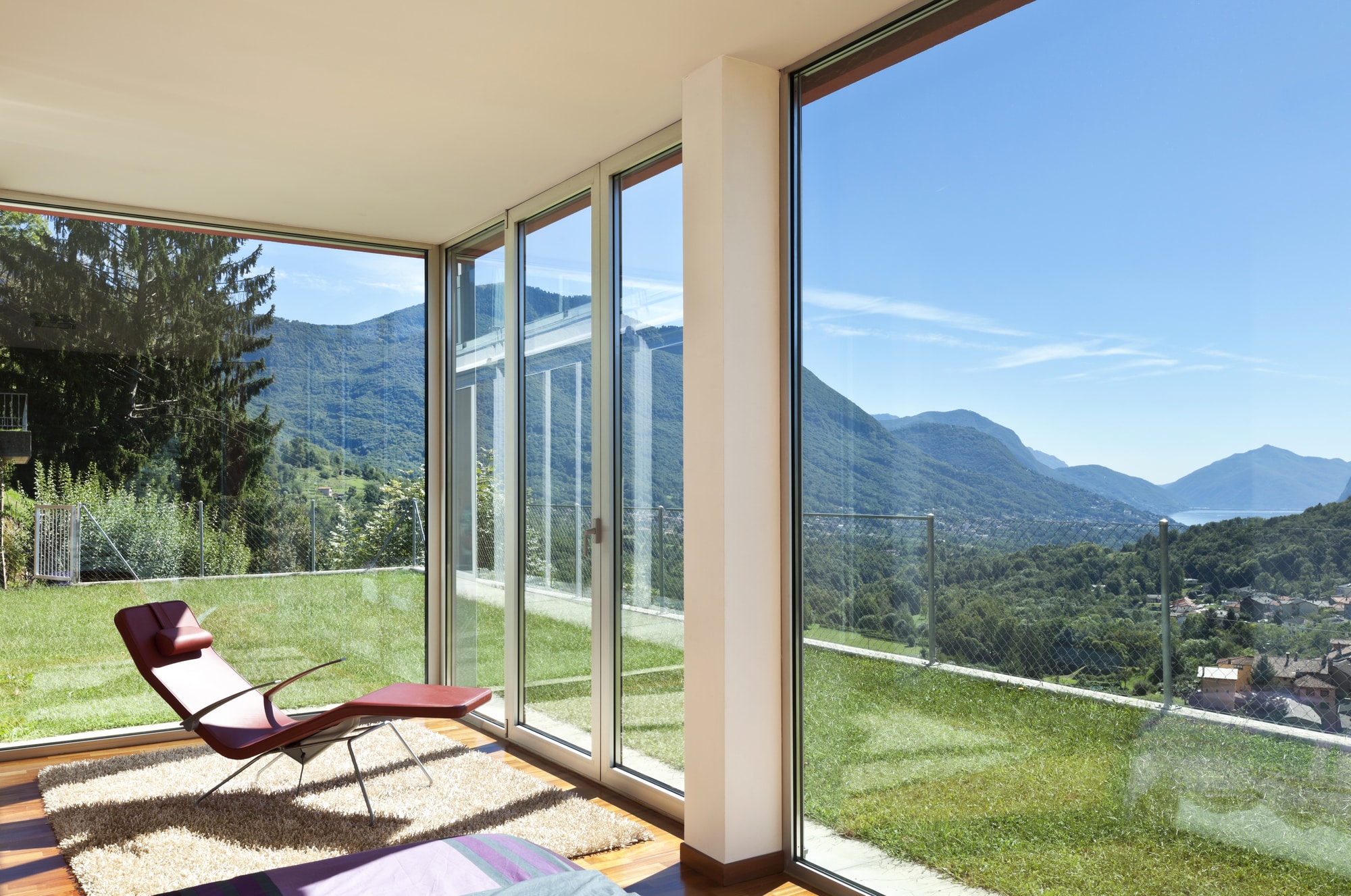 Modern home interior with moving glass wall looking out on hills