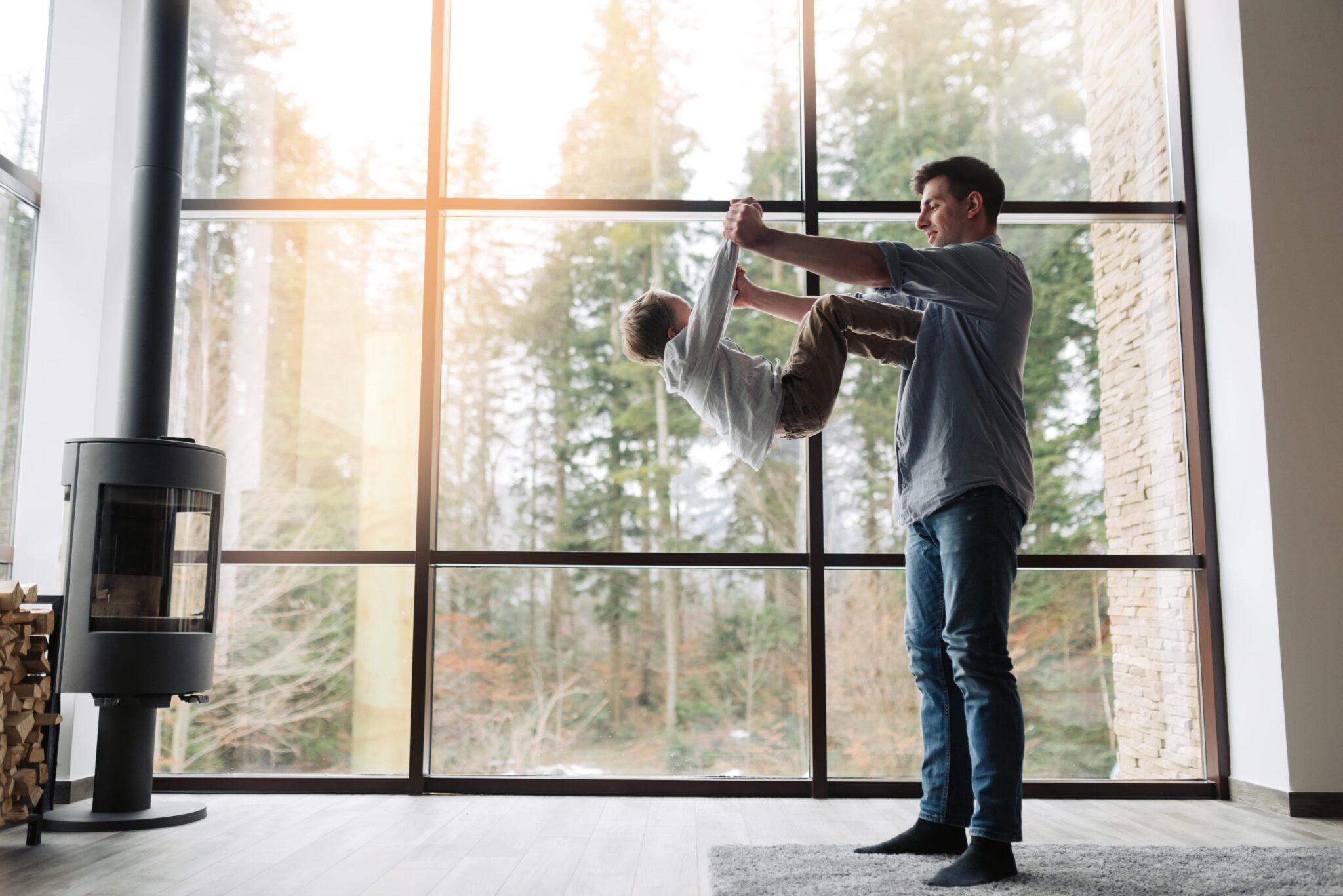 Father and son playing in front of big windows