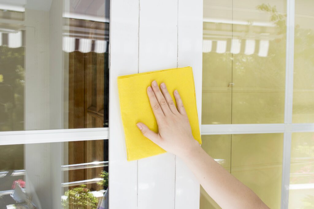 Cleaning white aluminum window with a microfiber cloth